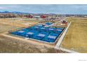 Aerial view of multiple new pickleball courts surrounded by park amenities and picturesque mountain views at 2117 Cadman St, Berthoud, CO 80513