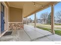 Expansive covered porch featuring stone detailing and ample space for relaxing outdoors at 2339 Whistler Dr, Longmont, CO 80504