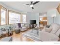 Bright living room featuring large windows, hardwood floors, and comfortable seating at 2437 Maplewood E Cir, Longmont, CO 80503
