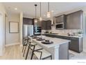 Sleek kitchen features gray cabinetry, stainless steel appliances, quartz countertops, and a breakfast bar for casual dining at 2746 Bear Springs Cir, Longmont, CO 80503