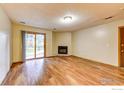 Bright living room featuring hardwood floors, a corner fireplace, and a sliding door leading to the backyard at 2865 Sundown Ln # 108, Boulder, CO 80303
