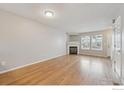 Open living room featuring hardwood floors, a fireplace, and plenty of natural light at 3006 W 107Th Pl # D, Westminster, CO 80031
