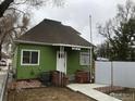 Charming single-story green home with a covered porch and well-maintained landscaping at 303 17Th Ave, Longmont, CO 80501