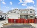Stunning two-story home with a red fence and attached garage, complete with camper at 3165 W 63Rd Ave, Denver, CO 80221