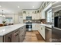 Modern kitchen features an island, stainless steel appliances, and bright white cabinets at 3165 W 63Rd Ave, Denver, CO 80221