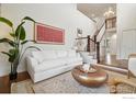Bright living room with a modern sofa, a golden coffee table, and stairway at 3940 Montclair Ln, Boulder, CO 80301
