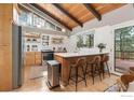 Bright, modern kitchen with a large island, stainless steel appliances, and wood-beamed ceilings at 661 Peakview Rd, Boulder, CO 80302