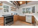 Well-lit kitchen with updated appliances, white subway tile backsplash, and wood cabinets at 661 Peakview Rd, Boulder, CO 80302