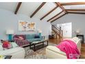 Spacious living room with vaulted ceilings, exposed beams, and a view of the staircase at 6914 Frying Pan Rd, Boulder, CO 80301