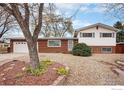 Charming two-story home with brick and siding exterior, landscaped with mature tree and rock ground cover at 10591 Park Ridge Ave, Longmont, CO 80504