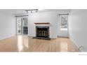 Bright living room with hardwood floors, fireplace, and sliding glass doors to a balcony at 11197 Alcott St # C, Denver, CO 80234