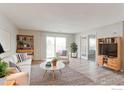 Bright living room featuring stylish furniture, light wood floors, and sliding glass doors to a balcony at 12180 Melody Dr # 203, Westminster, CO 80234