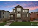 Inviting two-story home with stone accents and a green lawn at 1513 Chokeberry St, Berthoud, CO 80513