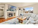 Cozy living room with a stone fireplace, large windows, a comfortable sofa, and a wooden coffee table at 1513 Chokeberry St, Berthoud, CO 80513