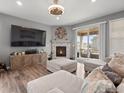 Inviting living room with a stone fireplace, plush seating, and a sliding glass door leading to the outdoor deck at 15788 Xanthia Way, Thornton, CO 80602