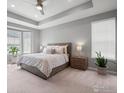 Serene main bedroom with a tray ceiling, ample natural light from the bay window, and neutral tones at 15788 Xanthia Way, Thornton, CO 80602