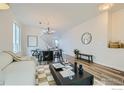 Open-concept living space with sleek furniture, modern lighting, and a view of the dining area at 230 Bonanza Dr, Erie, CO 80516