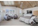 Serene bedroom with vaulted wood ceiling, ample natural light, and a sitting area at 2700 15Th St, Boulder, CO 80304