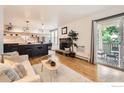 Open floor plan living room featuring hardwood floors, a fireplace, and access to a private balcony at 3035 Oneal Pkwy # V-11, Boulder, CO 80301