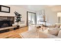 Cozy living room with a stone fireplace, hardwood floors, and access to a private outdoor patio at 3035 Oneal Pkwy # V-11, Boulder, CO 80301