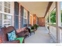 Inviting front porch with brick facade, cozy seating, and charming details that add to the home's curb appeal at 3050 N Torreys Peak Dr, Superior, CO 80027