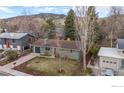 Aerial view of a charming home with lush greenery and mountain views, showcasing its serene and picturesque setting at 3545 Cloverleaf Dr, Boulder, CO 80304