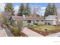 Well-maintained home with a charming facade, green lawn, and mature trees, complemented by a long driveway at 3545 Cloverleaf Dr, Boulder, CO 80304