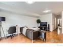 Open living area with hardwood flooring, comfortable seating, a desk, and a large TV, ideal for modern living at 3790 Iris Ave # B, Boulder, CO 80301