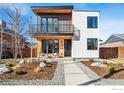 Modern two-story home boasts a stylish balcony, sleek black accents, and contemporary landscaping at 4455 Xavier St, Denver, CO 80212