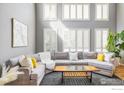 Sunlit living room with large windows, plush sectional, and stylish decor at 5001 Bella Vista Dr, Longmont, CO 80503