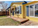 Side view of the home showing the yellow exterior and a covered porch area at 503 E Oak St, Lafayette, CO 80026
