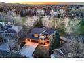 Beautiful aerial view of the brick home on a golf course, showcasing the yard and illuminated windows at 567 Manorwood Ln, Louisville, CO 80027