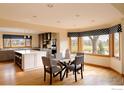 Inviting dining area and bright kitchen boasting a breakfast bar, stainless steel appliances, and scenic backyard views at 567 Manorwood Ln, Louisville, CO 80027