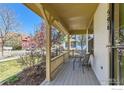 Charming front porch with wooden floors, seating and detailed columns offering a relaxing outdoor space at 596 Mills St, Lafayette, CO 80026