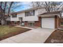 Charming split-level home boasts a spacious driveway and attached garage enhancing the property's curb appeal at 9 James Cir, Longmont, CO 80501