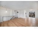 Bright living room featuring hardwood floors, an open layout, and plenty of natural light from large windows at 9 James Cir, Longmont, CO 80501