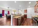 Open-concept kitchen with granite countertops, stainless steel appliances, and seamless flow into the dining area at 11180 Carbondale St, Firestone, CO 80504