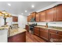 Well-equipped kitchen featuring granite countertops, stainless steel appliances, and custom cabinetry at 11180 Carbondale St, Firestone, CO 80504