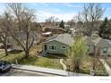 Aerial view of a single-story home featuring a well-maintained lawn, mature trees, and residential neighborhood at 117 Welch Ave, Berthoud, CO 80513
