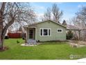 Charming single-story home with a well-maintained lawn, inviting curb appeal, and mature trees in a quiet neighborhood at 117 Welch Ave, Berthoud, CO 80513