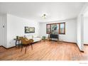 Bright living room featuring wood floors, a white sofa, and large window at 1501 Willow Dr, Berthoud, CO 80513