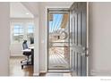 Open entryway featuring a stylish security door and a view into the adjacent home office at 17949 W 94Th Dr, Arvada, CO 80007