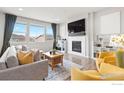 Bright living room with a cozy fireplace and large windows offering ample natural light at 17949 W 94Th Dr, Arvada, CO 80007