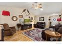 Comfortable living room featuring hardwood floors, vaulted ceilings, stylish decor, and a fireplace at 2518 Palmer Ave, Mead, CO 80542