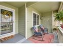 Inviting covered porch with comfortable seating, a cheerful wreath, and a 'hello' doormat at 2518 Palmer Ave, Mead, CO 80542
