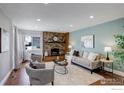 Comfortable living room with a brick fireplace, a stylish sofa, and two chairs at 319 Carter Ln, Longmont, CO 80501