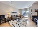 Cozy living room with a fireplace and sliding glass door to the balcony at 3260 47Th St # 108A, Boulder, CO 80301