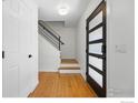 Bright entryway featuring hardwood floors, a modern front door with frosted glass, and stairs at 3495 Endicott Dr, Boulder, CO 80305