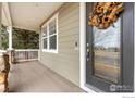 Close-up of front porch showcasing decorative door with wreath and stone accents at 4221 Pioneer Pl, Brighton, CO 80601