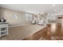 Bright living room with hardwood floors, large windows, and neutral decor at 4221 Pioneer Pl, Brighton, CO 80601